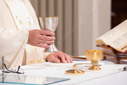 priest holding chalice during sacred eucharist ceremony