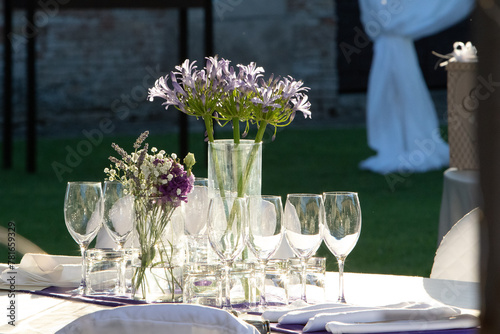 elegant table setting with purple floral centerpiece for an outdoor event