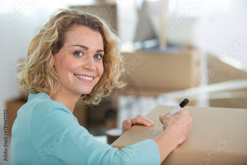 woman labeling moving box at home