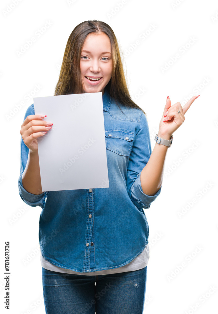 Young caucasian woman holding blank paper sheet over isolated background very happy pointing with hand and finger to the side Young caucasian woman holding blank paper sheet over isolated background very happy pointing with hand and finger to the side