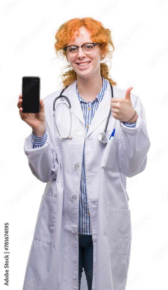 Young redhead doctor woman showing smartphone happy with big smile doing ok sign, thumb up with fingers, excellent sign Young redhead doctor woman showing smartphone happy with big smile doing ok sign, thumb up with fingers, excellent sign