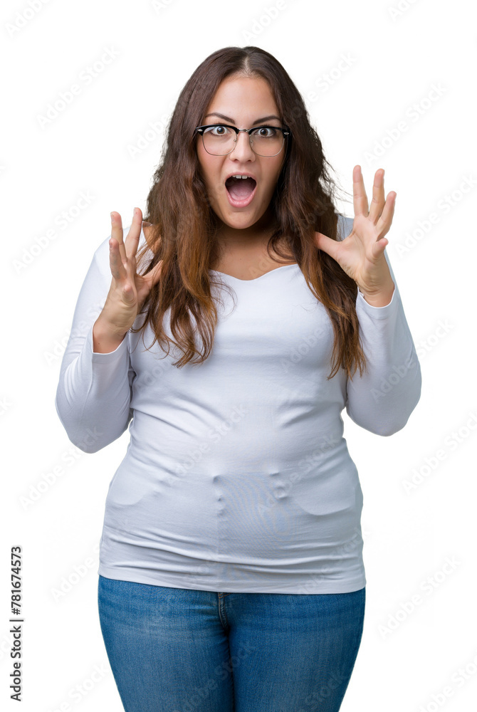 Beautiful plus size young woman over isolated background crazy and mad shouting and yelling with aggressive expression and arms raised. Frustration concept.