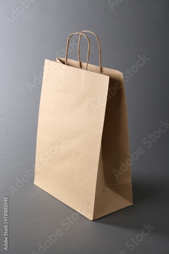 One kraft paper bag on grey background. Mockup for design