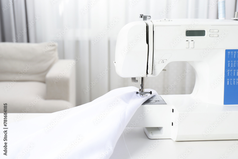 White sewing machine and fabric indoors, closeup