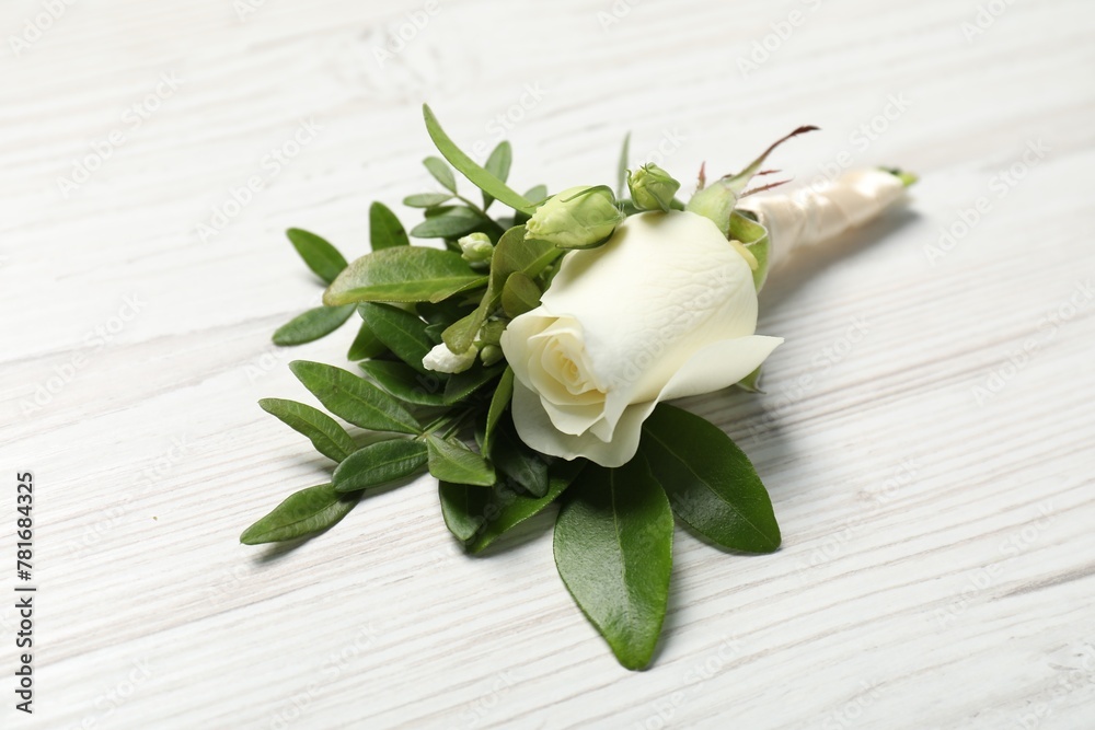 Wedding stuff. Stylish boutonniere on white wooden table, closeup Wedding stuff. Stylish boutonniere on white wooden table, closeup