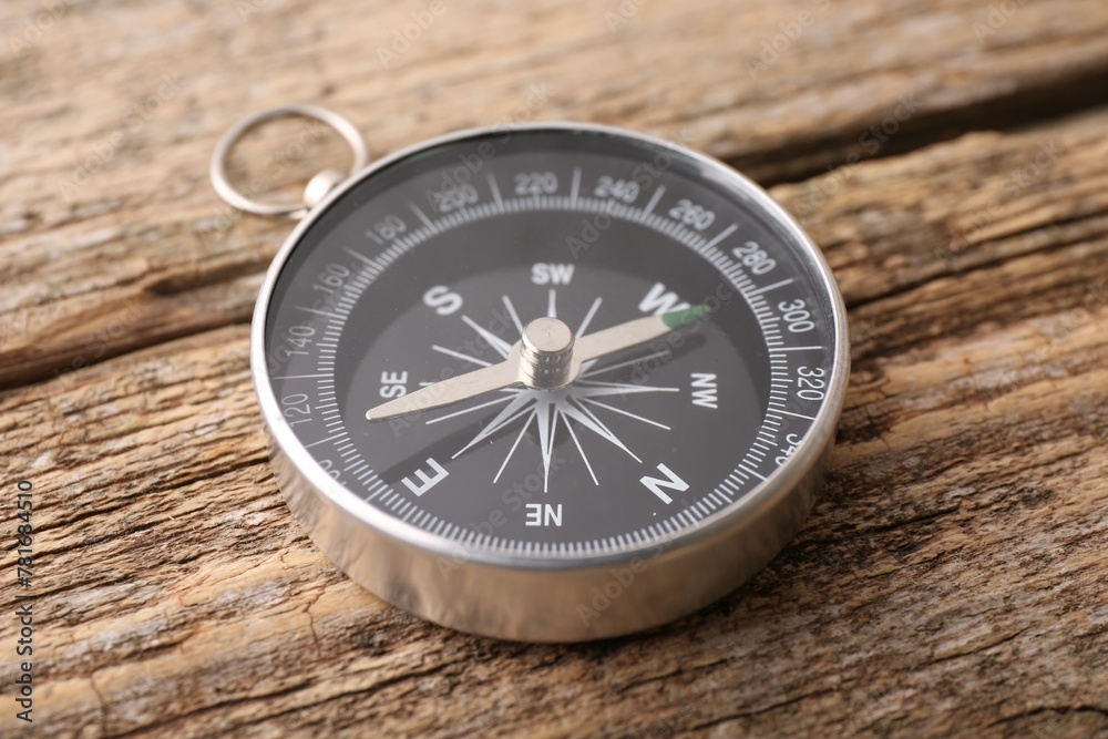 One compass on wooden table, closeup. Tourist equipment One compass on wooden table, closeup. Tourist equipment