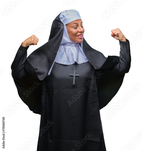 Middle age senior christian catholic nun woman over isolated background showing arms muscles smiling proud. Fitness concept.
