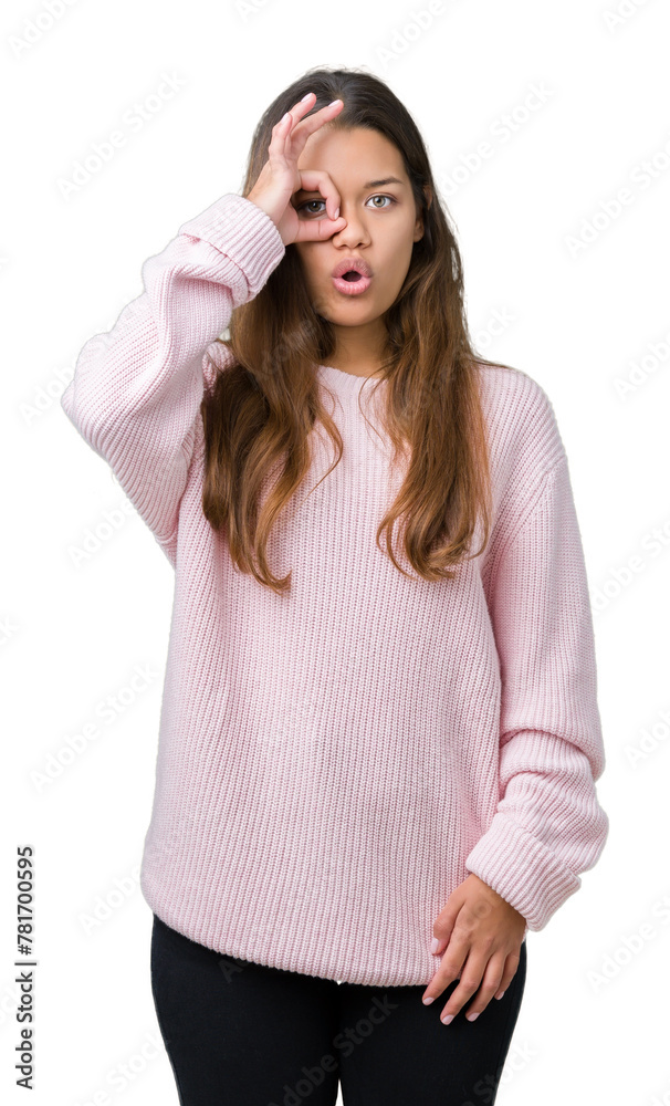 Young beautiful brunette woman wearing pink winter sweater over isolated background doing ok gesture shocked with surprised face, eye looking through fingers. Unbelieving expression. Young beautiful brunette woman wearing pink winter sweater over isolated background doing ok gesture shocked with surprised face, eye looking through fingers. Unbelieving expression.