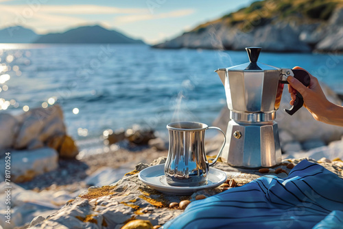 Hands making coffee with a Italian moka pot on a natural landscape near the ocean as background photo