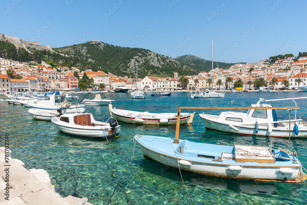 Boats at tied up in harbour with picturesque waterfront and town across bay Croatia