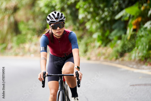 young asian professional woman cyclist cycling riding bike outdoors on rural road © imtmphoto