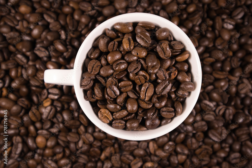 Widok kawy z góry w filiżance udekorowanej rozsypanymi ziarnami  kawy w tle