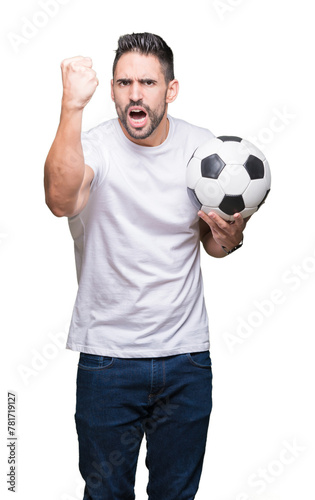 Young man holding soccer football ball over isolated background annoyed and frustrated shouting with anger, crazy and yelling with raised hand, anger concept