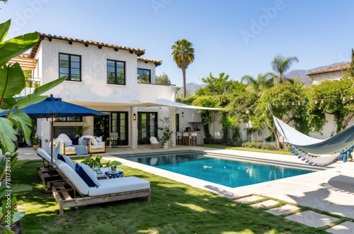 a small pool and outdoor living area in front, a modern house with white stucco walls and black steel frame construction. Patio furniture sits on a grassy area near the pool © Kien