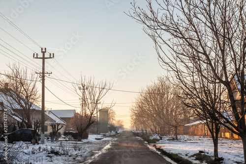 Panorama of a road and street in the village of crepaja, in Vojvodina, Banat, Serbia, in the countryside, during a cold freezing afternoon of winter with lots of snow. © Jerome