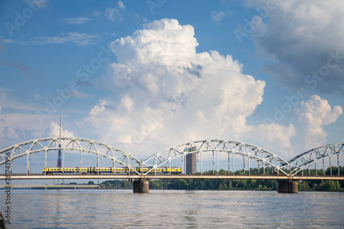 Panorama of the Daugava river in Riga, latvia, with a train from Latvian railways over dzelzcela tilts or Riga Railway Bridge with a skyline of business skyscrapers in background with high rise towers photo