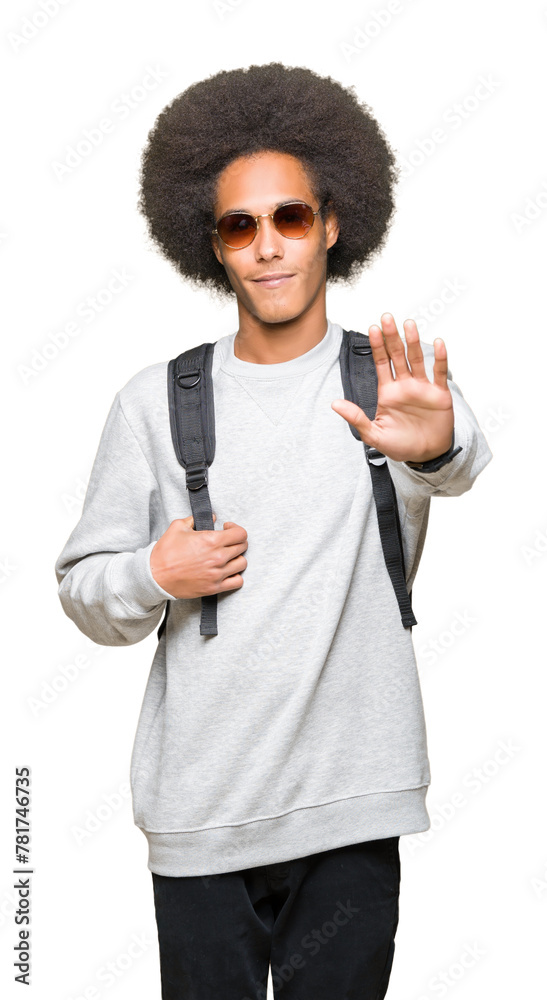 Young african american man with afro hair wearing sunglasses and backpack with open hand doing stop sign with serious and confident expression, defense gesture Young african american man with afro hair wearing sunglasses and backpack with open hand doing stop sign with serious and confident expression, defense gesture