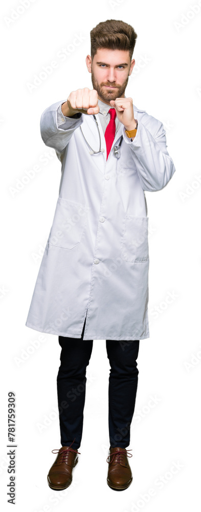 Young handsome doctor man wearing medical coat Punching fist to fight, aggressive and angry attack, threat and violence