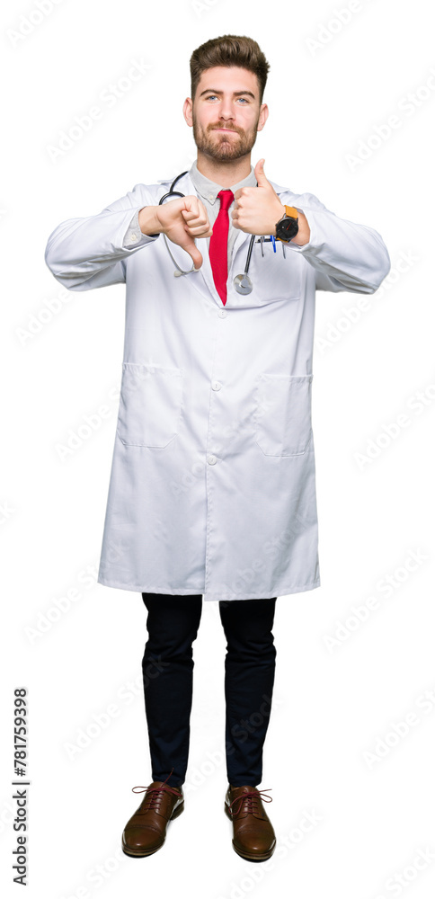 Young handsome doctor man wearing medical coat Doing thumbs up and down, disagreement and agreement expression. Crazy conflict Young handsome doctor man wearing medical coat Doing thumbs up and down, disagreement and agreement expression. Crazy conflict