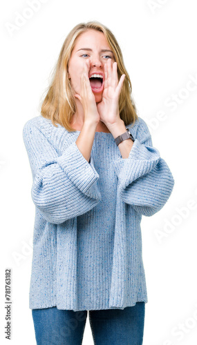 Beautiful young woman wearing blue sweater over isolated background Shouting angry out loud with hands over mouth