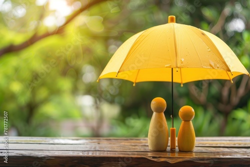 Two people are standing under a yellow umbrella.