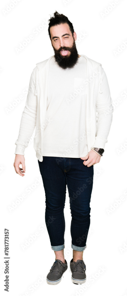 Young man with long hair and beard wearing sporty sweatshirt sticking tongue out happy with funny expression. Emotion concept. Young man with long hair and beard wearing sporty sweatshirt sticking tongue out happy with funny expression. Emotion concept.