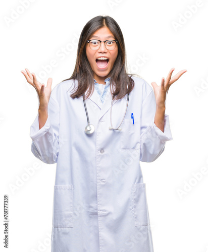Young asian doctor woman over isolated background celebrating crazy and amazed for success with arms raised and open eyes screaming excited. Winner concept