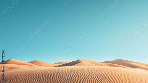 The rolling golden sand dunes form a serene, undisturbed desert landscape under a vast blue sky