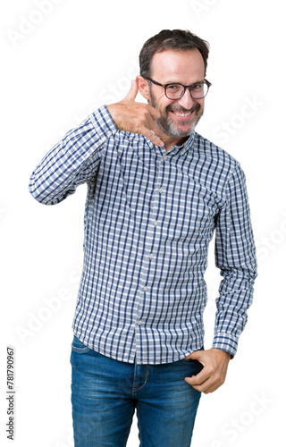 Handsome middle age elegant senior man wearing glasses over isolated background smiling doing phone gesture with hand and fingers like talking on the telephone. Communicating concepts.