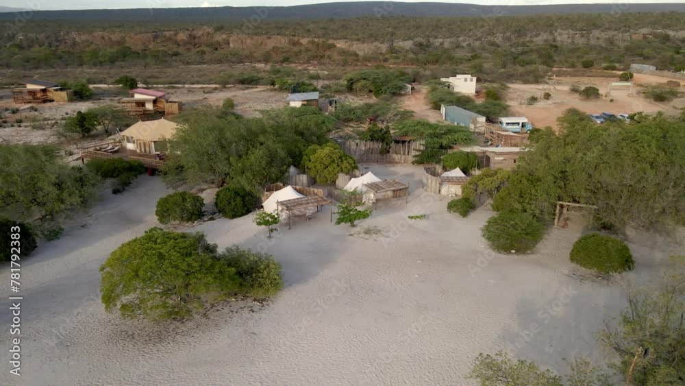 aerial view of small cabins surrounded by bushes on a paradisiacal beach aerial view of small cabins surrounded by bushes on a paradisiacal beach
