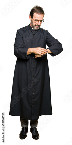 Middle age priest man wearing catholic robe Checking the time on wrist watch, relaxed and confident