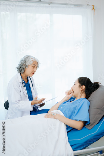  Doctor and young Female patient who lie on the bed while checking pulse, consult and explain with nurse taking note .