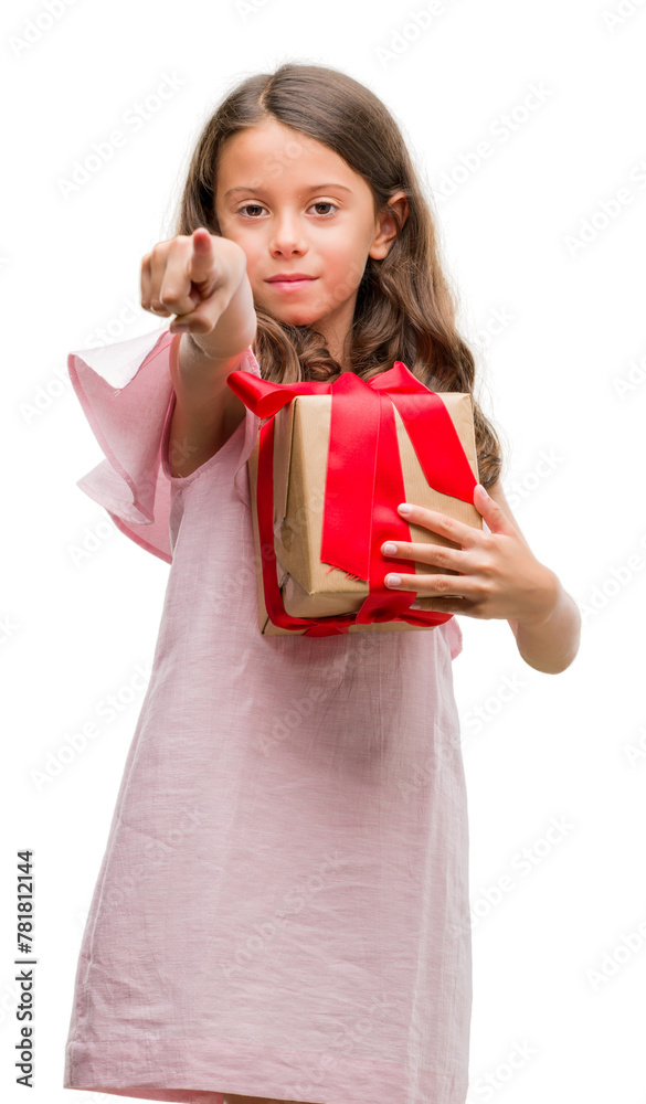 Brunette hispanic girl holding a gift pointing with finger to the camera and to you, hand sign, positive and confident gesture from the front Brunette hispanic girl holding a gift pointing with finger to the camera and to you, hand sign, positive and confident gesture from the front