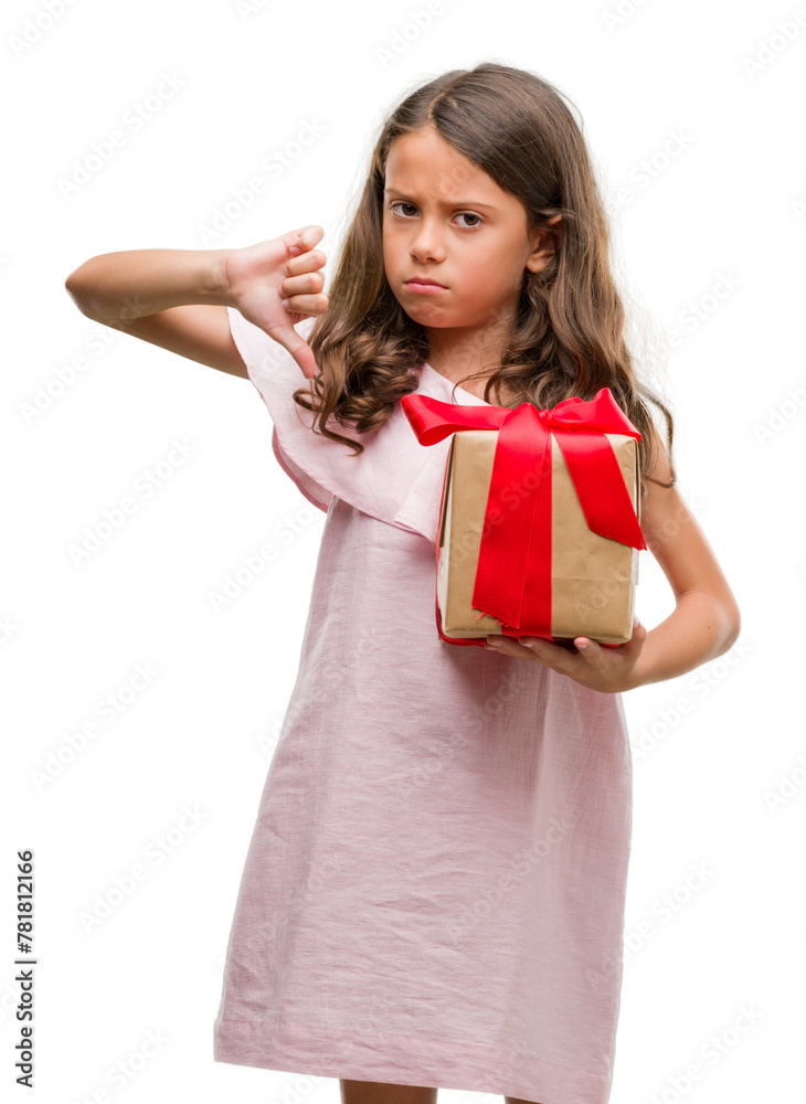 Brunette hispanic girl holding a gift with angry face, negative sign showing dislike with thumbs down, rejection concept Brunette hispanic girl holding a gift with angry face, negative sign showing dislike with thumbs down, rejection concept