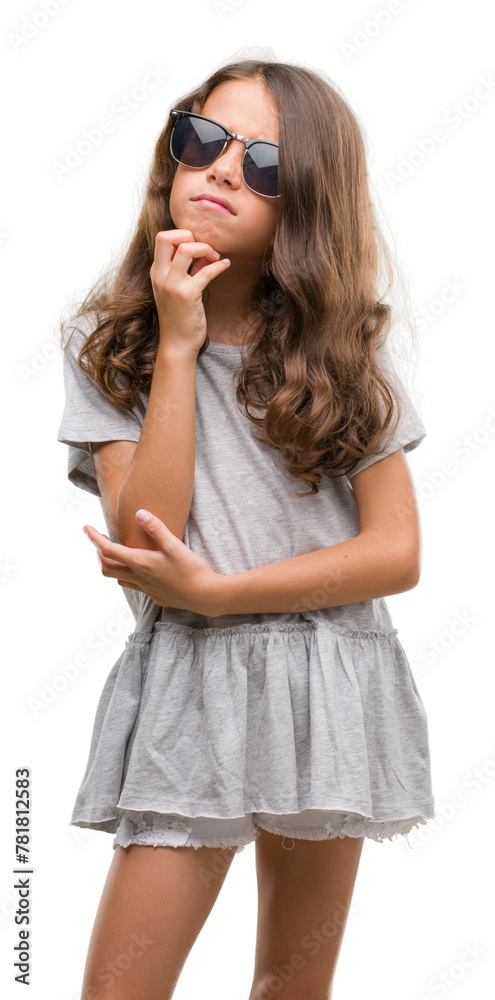 Brunette hispanic girl wearing sunglasses with hand on chin thinking about question, pensive expression. Smiling with thoughtful face. Doubt concept. Brunette hispanic girl wearing sunglasses with hand on chin thinking about question, pensive expression. Smiling with thoughtful face. Doubt concept.