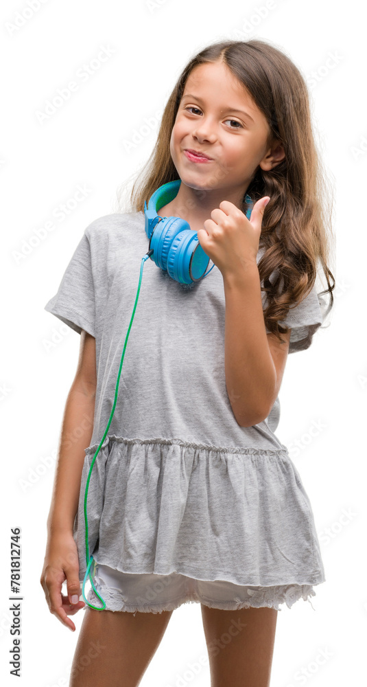 Brunette hispanic girl wearing headphones happy with big smile doing ok sign, thumb up with fingers, excellent sign Brunette hispanic girl wearing headphones happy with big smile doing ok sign, thumb up with fingers, excellent sign
