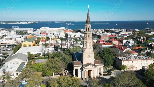 A drone shot of St. Philip's church in downtown charleston showing off the charleston harbor in the background. photo