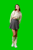 A woman wearing a white sweater and a gray skirt stands in a casual pose, showcasing her stylish outfit.