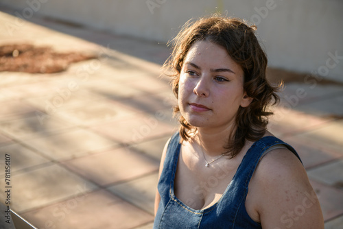 Portrait of a young pensive woman on background of a concrete wall