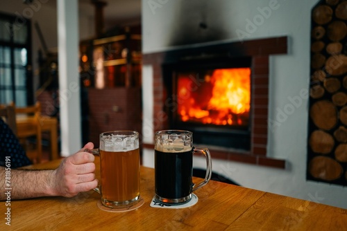 Photography Two glasses of beer, light and dark, in a pub near the fireplace