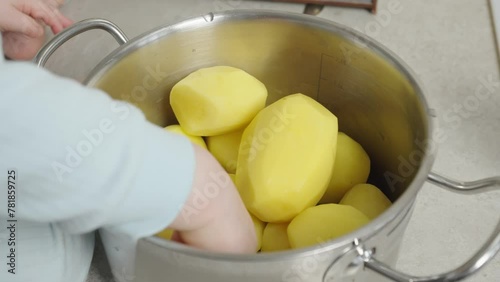 The video shows a child playing with potatoes in a pot, developing motor skills and imagination. Suitable for children's educational videos and toy commercials.