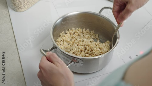 The video shows oatmeal cooking in a saucepan, demonstrating the process of preparing a healthy breakfast. Suitable for culinary clips and promoting a healthy lifestyle