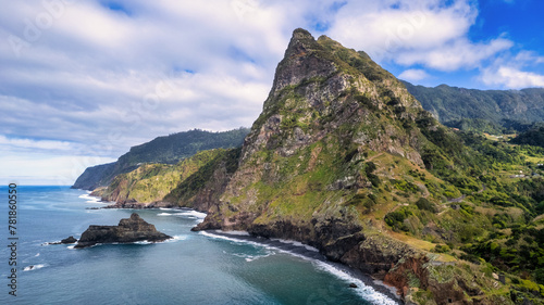 Breathtaking Madeira panorama - powerful cliffs, surging sea, foamy cascades, and lazy clouds. The contrast of raw nature with the blue sky amazes nature lovers photo
