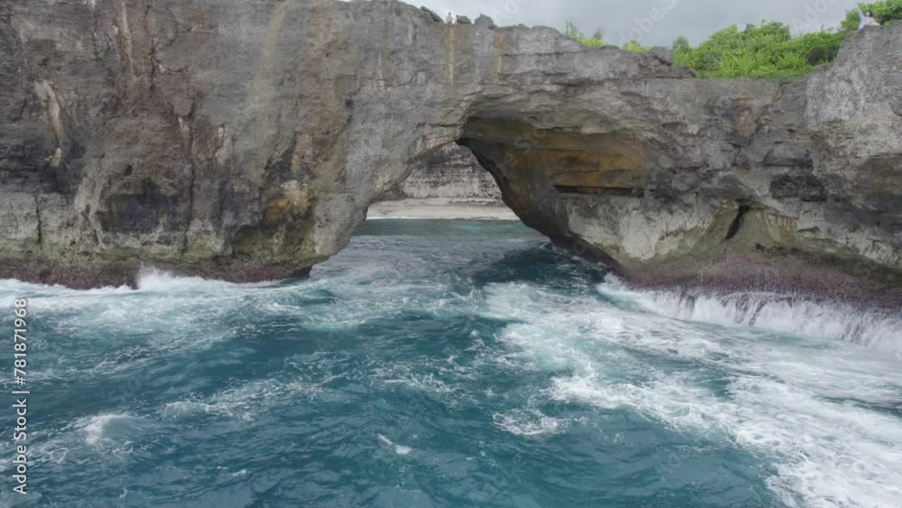 A large wave is crashing into a rocky shore. The water is choppy and the rocks are jagged A large wave is crashing into a rocky shore. The water is choppy and the rocks are jagged