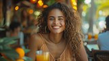 Smiling Young Woman Enjoying a Drink at an Outdoor Café