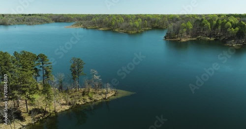 Green Foliage Surrounding Glenn Springs Lake In Drummonds, Tennessee, USA. drone tilt-down shot photo