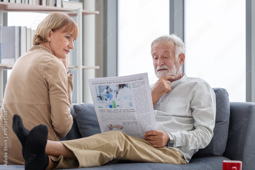 Obraz premium Senior couple spending time together in the living room, Retired man and woman reading newspaper, Happy family concepts