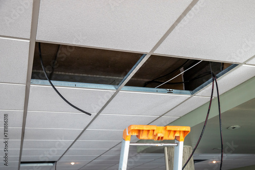 Installation au plafond de câble électrique pour alimenter des luminaires photo