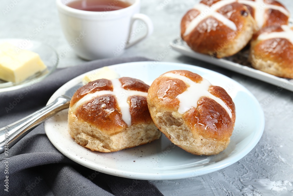 Tasty hot cross buns served on gray textured table, closeup