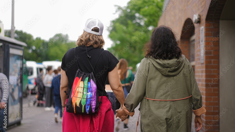 Happy lesbian couple walk lgbt pride. Two bi girl lovers go csd fest. Free same sex people coming out gay party. Dressed up love women. No stop homophobia. Queer community march. Rainbow lgbtq flag.